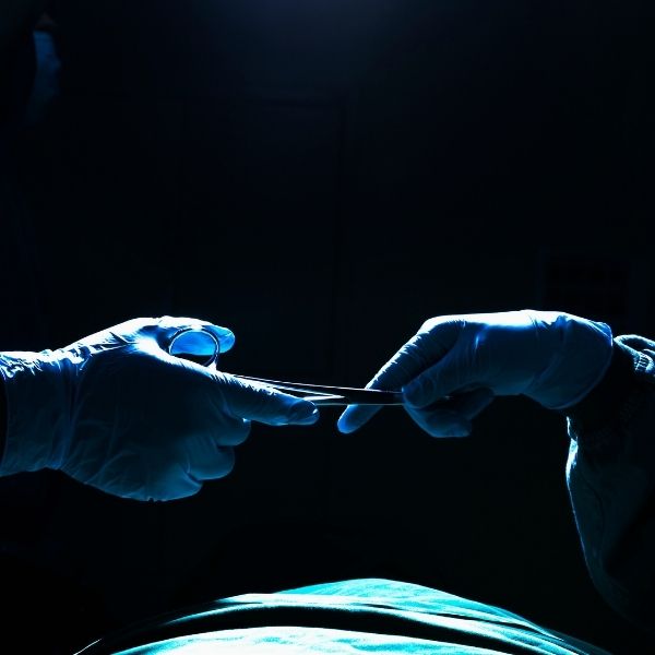 a podiatrist handing a surgical tool to another doctor a podiatrist handing a surgical tool to another doctor