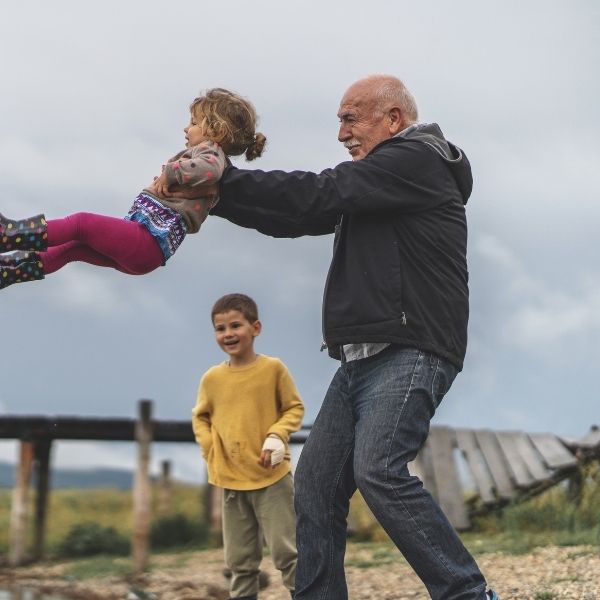 grandfather playing with grandkids outside after foot surgery