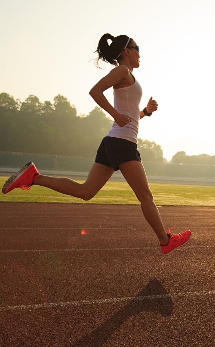happy woman running with orthotic inserts in her shoes