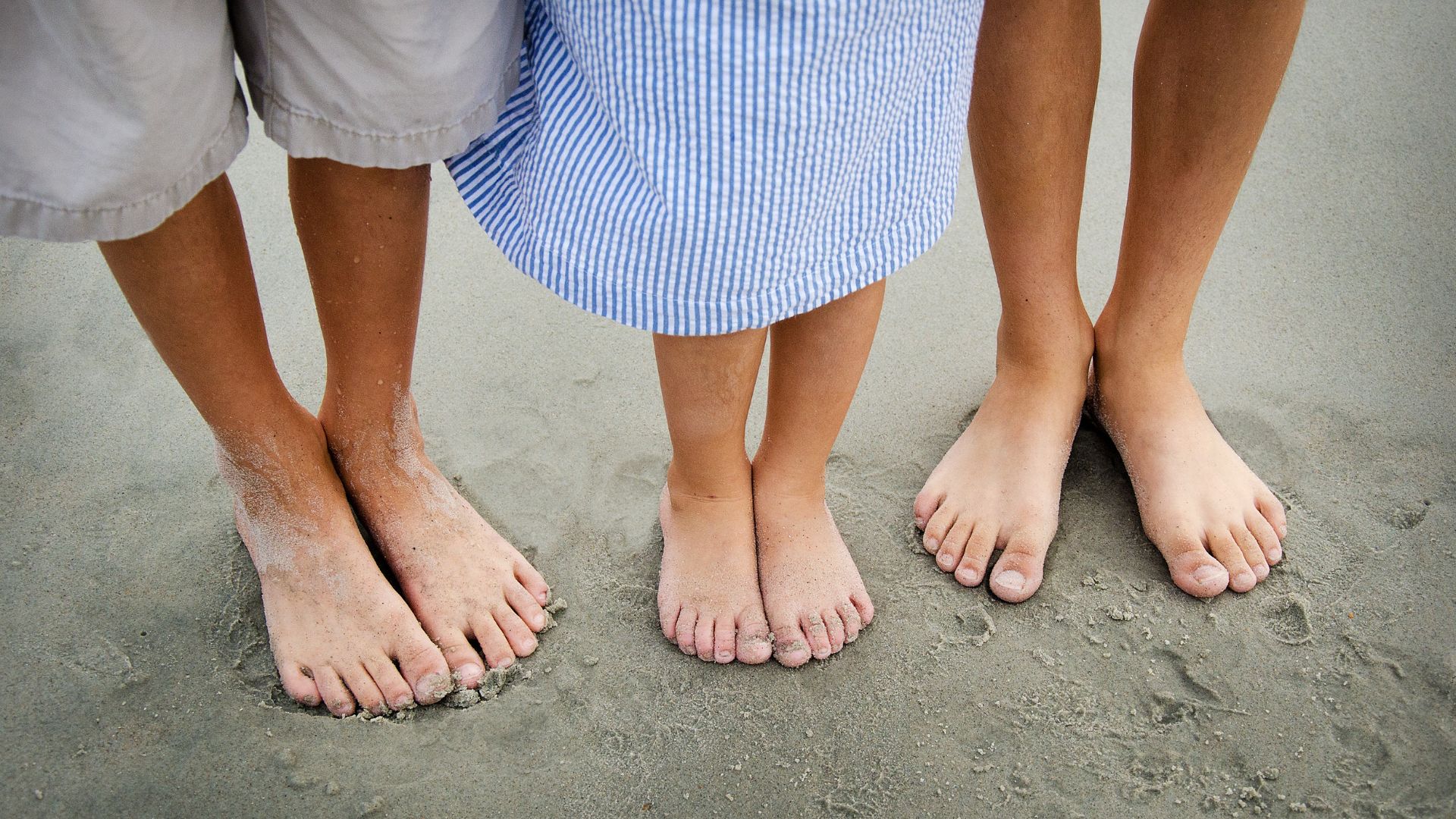 photo of 3 sets of feet on a Carolina beach