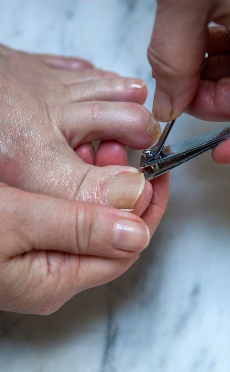 photo of a person cutting their toenails at home photo of a person cutting their toenails at home