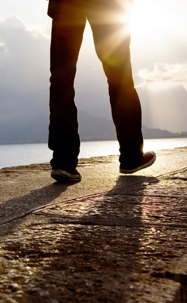 photo of a person walking against the sun