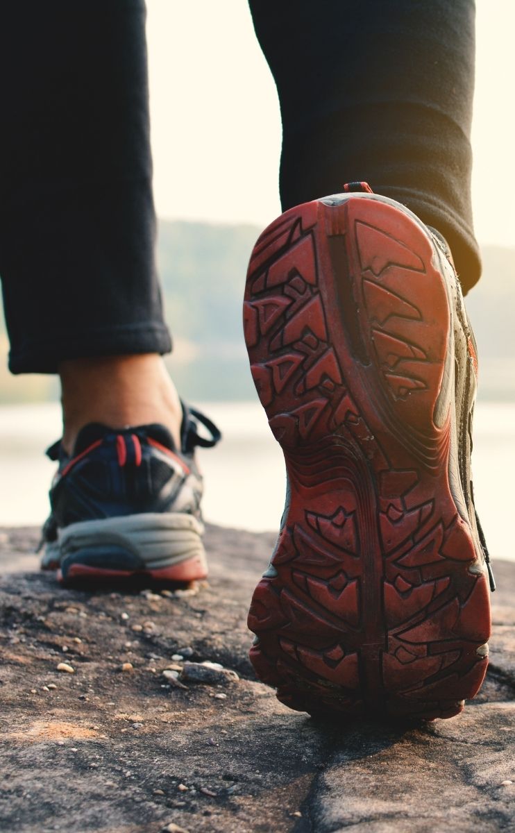 photo of the sole of a shoe as a man walks along photo of the sole of a shoe as a man walks along