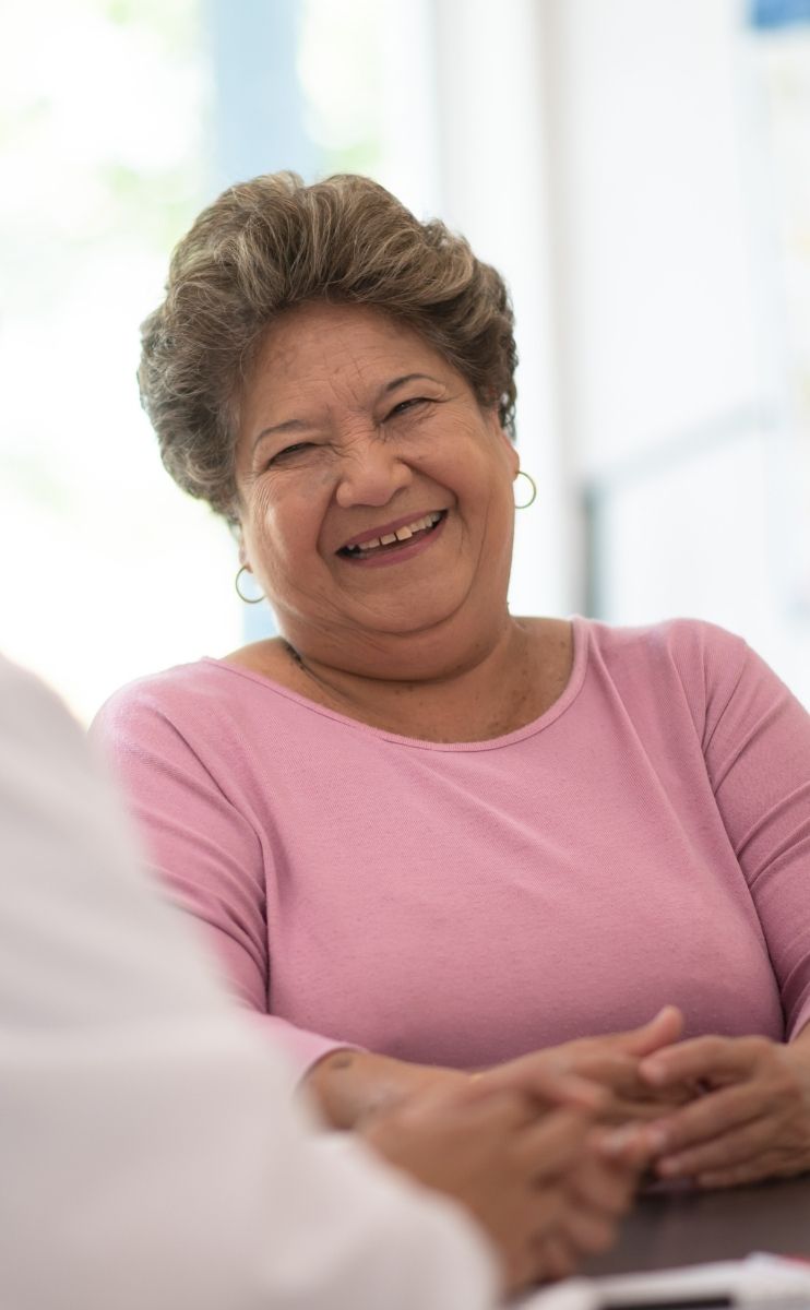 smiling woman talking to her podiatrist about bunion treatment options smiling woman talking to her podiatrist about bunion treatment options